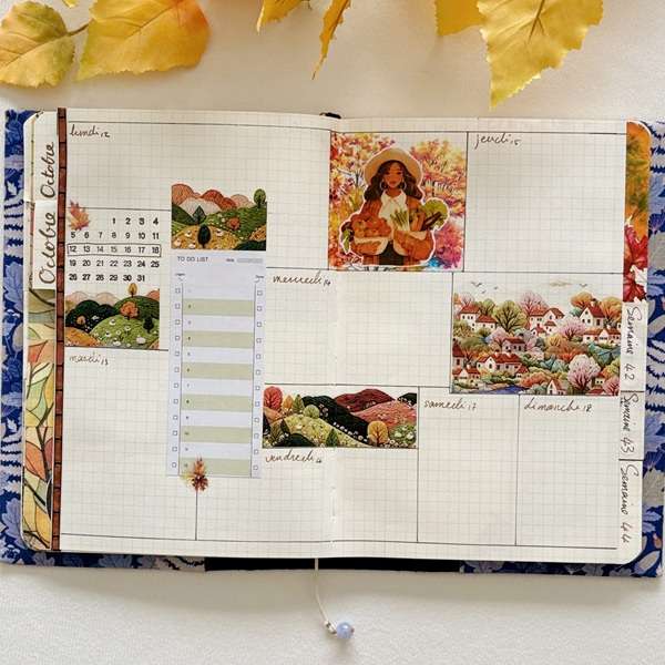 Double-page de bullet journal hebdomadaire décorée avec des stickers PET de villages, collines et paysages de campagne aux couleurs automnales.