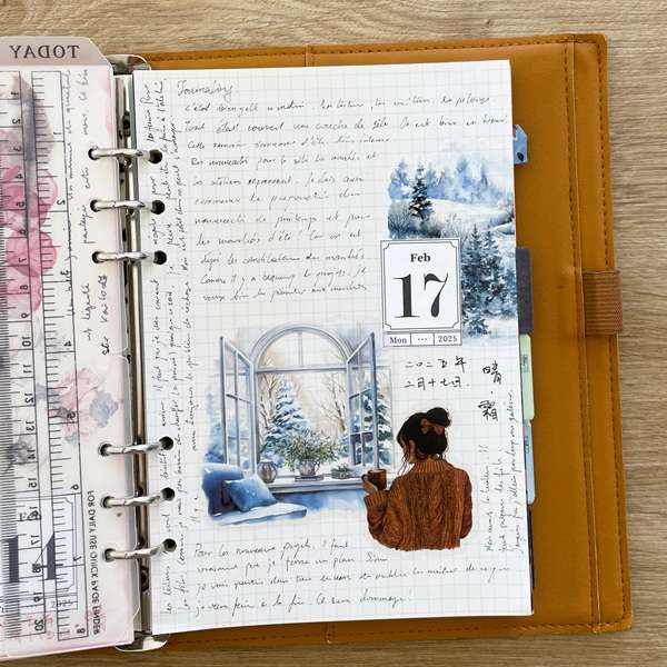 Page de bullet journal décorée avec un sticker PET représentant une jeune femme lisant, dans une ambiance hivernale.